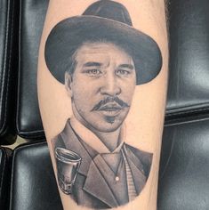 a man with a mustache and a hat on his leg is shown in this tattoo