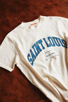 Saint Louis T shirt Easy 30 day return policy Collegiate Slogan Top For Streetwear, College Graphic Tee Tops, Collegiate Graphic Print Tops For Summer, College Graphic Tee Tops With Graphic Print, Collegiate Summer Streetwear Tops, Summer Logo Print Fan Apparel Tops, Summer Fan Apparel Tops With Logo Print, Summer College Tops With Logo Print, Sporty Everyday Tops With Logo Print