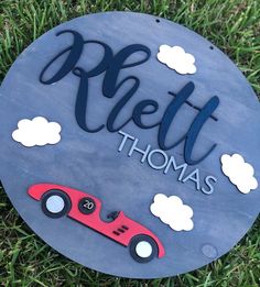 a blue plaque with a red car on it that says,'petit thomas '