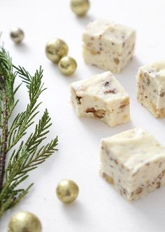 several pieces of food sitting on top of a white surface next to christmas decorations and gold balls