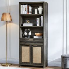 a book shelf with books and headphones on it next to a lamp in a living room