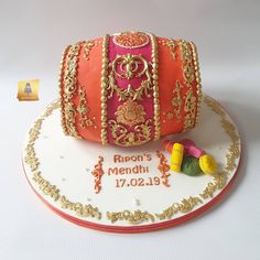 a birthday cake decorated with an orange and pink purse on top of a white plate