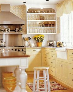 a kitchen filled with lots of counter top space and white cupboards covered in glassware