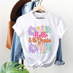 Fifth grade floral retro t-shirt for any future or current fifth grade teacher that wants to go back to school in style! This shirt will be a great addition to the wardrobe and can be dressed up or down, with jeans or even a skirt. It's colorful and screams happy! All items are made to order and will ship within a week from one of Printing Partners. Please allow for sufficient time for production and shipping, especially during busy seasons/holidays.  Please review your order before purchasing a White T-shirt For School In Spring, White T-shirt For Spring, Spring Graphic Print T-shirt For School, Retro T-shirt For Spring School Days, Spring School Short Sleeve T-shirt, School Short Sleeve T-shirt For Spring, Spring School Tops With Funny Print, Short Sleeve School T-shirt For Spring, Short Sleeve T-shirt For School In Spring