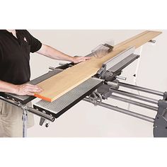 a man standing next to a table sawing