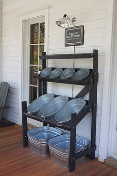 a black metal rack with buckets on it in front of a white wall and door