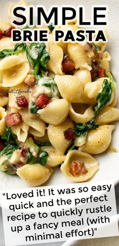 a white bowl filled with pasta and spinach