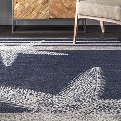 a blue and white area rug with an arrow design on the bottom in front of a wooden cabinet