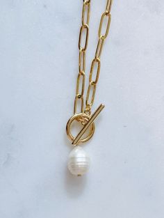 14k gold plated paperclip chain necklace with a toggle clasp and a plain pearl dangling in the middle. Necklace is 14 inches in length. Available with or without a dainty turquoise gem attached. Chic Toggle Necklace With Paperclip Chain For Everyday, Chic Toggle Necklace With Paperclip Chain As Gift, Elegant Dangle Charm Necklace With Paperclip Chain, Chic Everyday Toggle Necklace With Paperclip Chain, Baroque Pearl Paperclip Chain Jewelry Gift, Elegant Paperclip Chain Toggle Necklace, Gold Toggle Necklace With Paperclip Shape, Gold Necklace With Baroque Pearl And Paperclip Chain, Elegant Gold-tone Paperclip Chain Charm Necklace