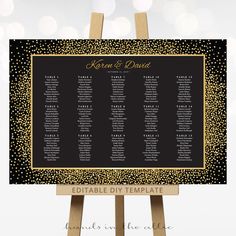 a black and gold wedding seating chart on an easel with sparkles in the background