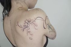 the back of a woman's shoulder with flowers on it