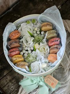 a white bowl filled with assorted pastries and flowers