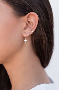 The Croix earrings are small hoops with a cross-shaped pendant. This minimalist and easy-to-combine earrings are really comfortable due to their lightness. They look great on both adults and children. Perfect for a gift, too. Features: * Inner diameter: 9 mm. * Outer diameter: 11 mm. * Cross length: 13 mm. * They are sold in singles and in pairs. Both options are available on the dropdown menu. * All of our jewelry is made with sterling silver (925 mm) and our gold jewelry is gold plated in 18K Earrings Cross, Tiny Hoop Earrings, Hammered Hoop Earrings, Peridot Earrings, Crescent Moon Earrings, Earrings Hoop, Cross Earrings, Moon Earrings, Simple Earrings