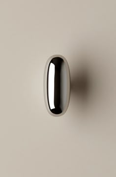 a white and black door handle on a gray wall with no one in the photo