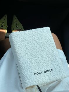 a book that is sitting on top of a woman's lap with high heels