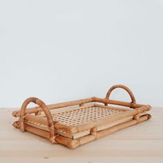 a bamboo tray with handles on a wooden table