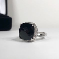 Gorgeous Black Onyx & Sterling Ring * Genuine Cushion Cut Black Onyx measures 12x12mm * Brilliant Cut Cubic Zirconia accents * Solid Sterling Silver * Size 6, 7 or 8 - Select Your Size Hallmarked & Gift Ready! TIMELESS, BEAUTIFUL & UNIQUE FINE ART JEWELRY! Formal Black Rings With Black Diamonds, Classic Black Jewelry With Accent Stones, Formal Black Rings With Accent Stones, Black Formal Jewelry With Accent Stones, Black Jewelry With Halo Setting For Anniversary, Black Jewelry With Halo Setting For Formal Occasions, Fine Jewelry Black With Accent Stones, Fine Black Jewelry With Accent Stones, Formal Black Diamond Jewelry