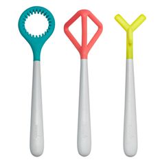 three different colored toothbrushes sitting next to each other