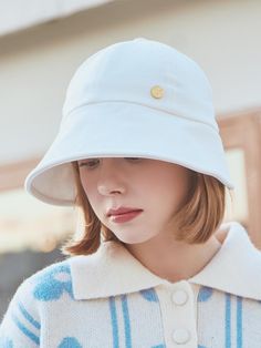 a woman wearing a white hat and sweater