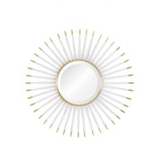 a white and gold sunburst mirror sitting on top of a table