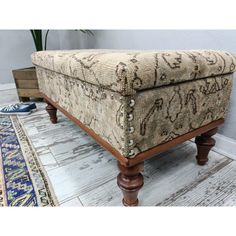 a footstool sitting on top of a wooden floor next to a blue rug