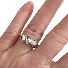 a woman's hand with an engagement ring on top of her finger, showing three diamonds