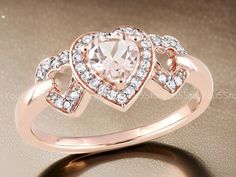 an engagement ring with a heart shaped pink diamond in the center and diamonds around it