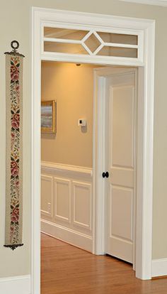 an open door leading to another room with wood floors and white trim on the walls