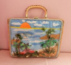 "This marvelous vintage 1950s-1960s Made in Hong Kong purse is created in gorgeous beige woven wicker with a beautiful vinyl encased artistic beach scene, which includes flamingos, an alligator, a shark, as well as palm trees, sea grass and other foliage.  There are a scattering of sea shells and a felt background complete with ocean waves, sandy beach and blue skies, as well as an orange sun.  There is a white strip of sequins to denote the tide.  Braided blue trim surrounds the vinyl window and there are brass rivet feet with leather hinges, as well as brass hardware on top with a twist closure and a movable handle.  The interior is lined in vinyl with a convenient pocket.  The inside label reads:  \"Made in Hong Kong.\"  Measurements for this fabulous creation are:  Height from top to b Vintage Handmade Straw Travel Bag, Retro Summer Travel Straw Bag, Handmade Vintage Straw Bag For Travel, Vintage Rectangular Straw Bag For Beach, Retro Rectangular Straw Travel Bag, Vintage Straw Travel Bag, Vintage Straw Bag For Travel, Vintage Woven Straw Bag For Beach, Vintage Woven Straw Bag For Vacation