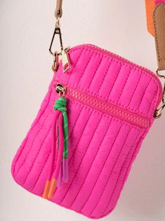 a pink purse hanging from the side of a wall with a keychain attached to it