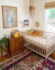 a baby crib in the corner of a room next to a dresser and window