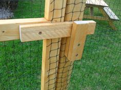 a close up of a wooden fence with a chicken in the back ground behind it