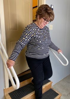 an older woman is walking up some stairs