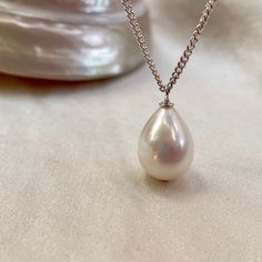 A stunning single pearl pendant necklace, on a sterling silver chain. * 13mm x 10mm teardrop freshwater pearl  * 16"/40cm fine sterling silver chain (not your length? message me) * boltring clasp * classic minimalist design  A truly beautiful white freshwater pearl with natural pink colours in its fabulous lustre. This perfect teardrop shaped pearl has natural banding which only adds to its unique allure.  Hanging from a recycled sterling silver curb chain, this pearl pendant necklace is perfect Classic Pear Shaped Drop Gift, Classic Pear-shaped Drop Gift, Classic Teardrop Necklace With Pearl Charm, Classic Teardrop Pearl Chain Necklace, Classic Necklace With Teardrop Pearl Charm, Pearl Drop Teardrop Necklace, Minimalist Pearl Drop Necklace With Charm, Elegant Teardrop Pearl Chain Necklace, Elegant Teardrop Drop Necklace With Pearl Charm