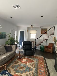 a living room filled with furniture and a stair case