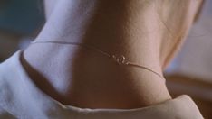 the back of a woman's neck wearing a silver bracelet