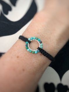 a woman's arm with a bracelet on it and a beaded ring in the middle