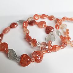 "If you have any other Welcome to my \"MajesticCrystalVibez\" Shop You are viewing \"Orange Hearts Bead Crystal Bracelet with sunstone Arusha charm | Protection Crystal Bracelet | Natural Sunstone Healing Jewelry | Handmade\" etsy listing. Our exquisite Orange Hearts Bracelet adorned with a mesmerizing sunstone Arusha charm. This delightful piece exudes elegance and charm, making it the perfect accessory for any occasion. Handmade with love, this bracelet is not only a stunning fashion statement Orange Spiritual Gemstone Bracelets, Spiritual Orange Gemstone Bracelets, Orange Bracelets With Natural Stones For Gifts, Orange Natural Stone Bracelets As Gift, Orange Natural Stone Bracelet For Gift, Orange Gemstone Beads Crystal Bracelet As Gift, Orange Crystal Bracelet With Gemstone Beads As Gift, Adjustable Orange Gemstone Bracelets, Orange Beaded Bracelet With Heart Beads As Gift