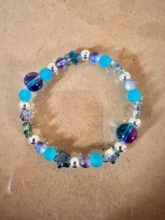 "This is a handmade bracelet.  Very pretty turquoise blue color with shiny star accent beads on a stretchy elastic. Would fit a 7\" wrist easily.  The accent pieces are metallic looking and change color based on the lighting. Picture taken in different lighting to show how it looks under different settings. We offer free shipping on all of our items! If you are interested in a certain color combination, please send me a private message to see if we have your desired colors in stock. Thank you fo Turquoise Blue Color, Stackable Jewelry, Bleu Turquoise, Stackable Bracelets, Jewelry For Her, Gift Jewelry, Handmade Bracelet, Silver Turquoise, Color Combination