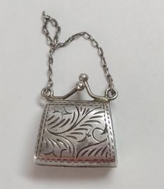 Sterling silver vintage purse charm locket. It has a hinge on the bottom so it can open up. The clasps at the top snap it tight. 4.9 grams  **This is one of our beautiful and unique vintage pieces that we purchased "over the counter" or from an estate sale.  Each piece goes through our Accredited Gemologist Association AGA certified laboratory to check the identity of the stones, metal type and quality.  It is preloved and in great condition.  We enjoy these pieces of history that give us a glimpse of the past but we are not a museum.  We price our jewelry to sell to keep our inventory moving forward and fresh.  Check back often to see new listings.  Thank you for visiting our shop.  Please contact us with any questions. Vintage Hallmarked Silver Locket Necklace, Vintage Rectangular Jewelry For Everyday Use, Antique Sterling Silver Locket Necklace For Formal Occasions, Collectible Hallmarked Silver Locket Necklace, Silver Hallmarked Locket Necklace Collectible, Elegant Silver Locket Necklace Stamped 925, Vintage 925 Stamped Jewelry Keepsake, Vintage Stamped 925 Jewelry Keepsake, Compact Silver Jewelry For Formal Occasions