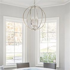 a dining room table with four chairs and a chandelier hanging from the ceiling