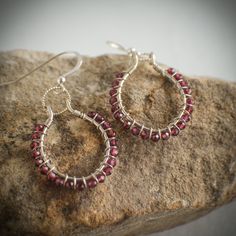 Garnet and sterling silver hoop earrings.  This listing features a pair of sterling hoops that were hand formed and lightly hammered.  Each hoop was wrapped with 21 genuine 3mm garnet beads.  Each hoop dangles from a sparkling twisted soldered sterling silver jump ring and sterling silver ear wire.  Each earring is a little over 1 inch in diameter and dangles just about 1.5 inches from the earlobe.  Very lightweight and easy to wear. These earrings will arrive boxed and ready for gift giving.  O Oval Gemstone Hoop Earrings As Gift, Oval Gemstone Hoop Earrings For Gift, Gemstone Hoop Jewelry Gift, Gemstone Hoop Jewelry For Gifts, Sterling Silver Hoop Jewelry Gift, Sterling Silver Hoop Jewelry As Gift, Sterling Silver Hoop Jewelry For Gifts, Red Sterling Silver Hoop Earrings, Red Sterling Silver Round Hoop Earrings