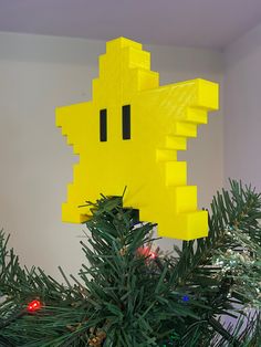 a yellow pacman ornament hanging from a christmas tree