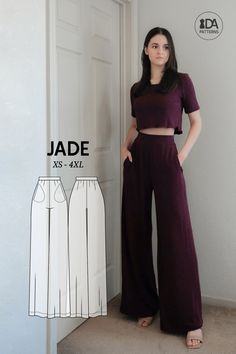 a woman standing in front of a door wearing wide legged pants and cropped top