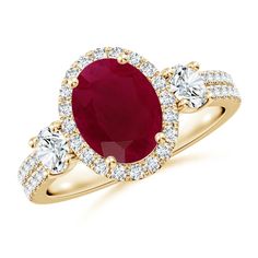 an oval shaped ruby and diamond ring with three diamonds around the band, set in yellow gold