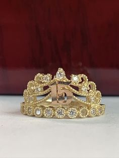 "Celebrate a Quinceañera in style with this exquisite 14K Tri-color Gold Ring, featuring a captivating rose gold crown adorned with cubic zirconia. The intricate crown design adds a touch of regal elegance to this piece, making it a perfect symbol for a sweet 15 birthday celebration. Weighing 3.1 grams and proudly stamped with \"14k\" for authenticity, this ring is crafted from solid gold, ensuring its enduring quality and value. It's a beautiful and meaningful accessory, commemorating a special milestone with timeless grace and sophistication." 15 Rings Quinceanera Gold, Quince Rings Gold, Xv Jewelry, 15 Rings Quinceanera, Quinceañera Rings, Quinceanera Crowns Gold, Quinceanera Rings, Quince Rings, Tri Color Gold Rings