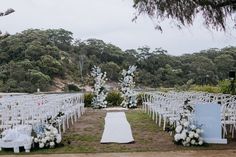 an outdoor wedding setup with white chairs and flowers