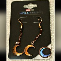 pair of earrings with moon and crescent design on card for sale in store window display