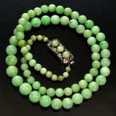 "All original jadeite jade bead necklace from 1920's. Fine polished graduated undyed natural jadeite jade beads are of a great green color. The largest beads are 10 mm (3/8\"), the smallest are 5 mm (3/16\"). The necklace is 22 1/2\" long ending with sterling silver push-in clasp adorned with 3 jade cabochons of the same color as the other beads. The clasp is also embellished with beautiful grape leaves repousse. It measures just under 1\" long, 3/8\" wide. There is no hallmarks, the clasp teste Classic Jade Necklace With Round Beads, Classic Jade Necklaces With Round Beads, Classic Green Jewelry With 8mm Beads, Classic Jade Gemstone Beads Jewelry, Vintage Single Strand Jade Jewelry, Vintage Jade Jewelry Hand-strung, Vintage Jade Jewelry With Round Beads, Vintage Jade Necklaces With Round Beads, Vintage Jade Bead Necklaces