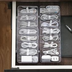 an open drawer with several different types of cords and accessories in it, including a pen